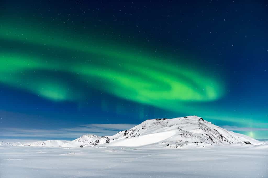 De ultieme gids voor het fotograferen van het noorderlicht 1 Noorderlicht boven besneeuwde bergen op IJsland